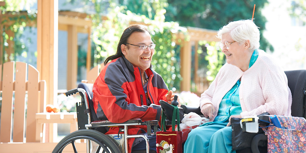 ways-to-give man and woman in wheelchair smiling as they face one another and talk
